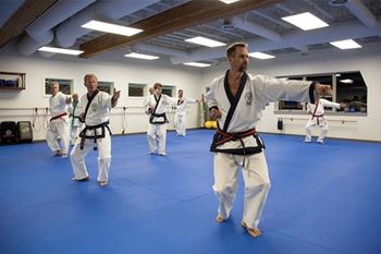 A group of people practicing karate in a blue-carpeted room. at Lido Apartment Homes @ Hailey, ID, Hailey, ID, 83333